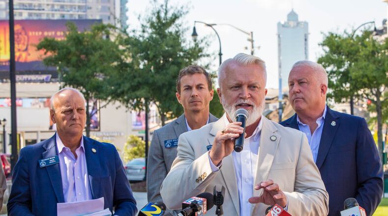Republican state Sen. Randy Robertson of Cataula (at podium) is among the lawmakers who support the creation of the "City of Buckhead City." He is pictured at a 2021 event in Loudermilk Park.  (Jenni Girtman for The Atlanta Journal-Constitution)