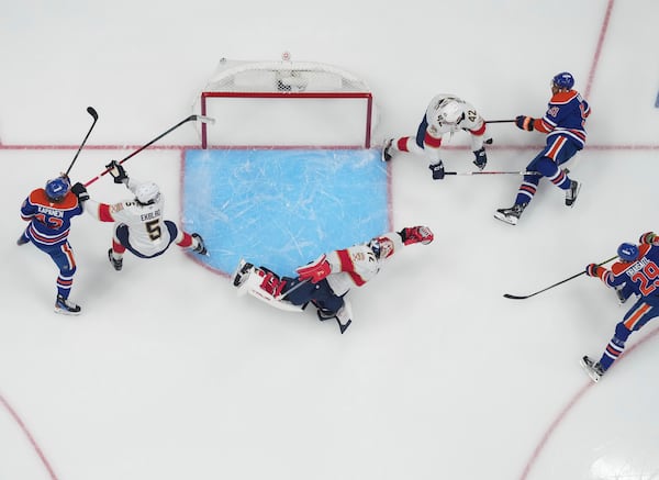 Edmonton Oilers' Leon Draisaitl (29) scores against Florida Panthers goalie Sergei Bobrovsky (72) as Aaron Ekblad (5) and Gustav Forsling (42) defend while Edmonton's Kasperi Kapanen (42) and Evander Kane (91) watch during the first overtime period in Game 1 of the NHL Stanley Cup Final, in Edmonton, Alberta, on Wednesday, June 4, 2025. (Darryl Dyck//The Canadian Press via AP)