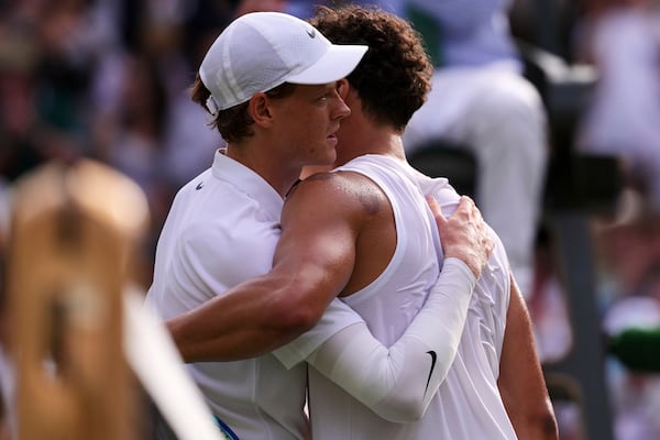 Jannik Sinner of Italy and Ben Shelton of the U.S. hug after the men's singles quarter final match at the Wimbledon Tennis Championships in London, Wednesday, July 9, 2025.(AP Photo/Kirsty Wigglesworth)