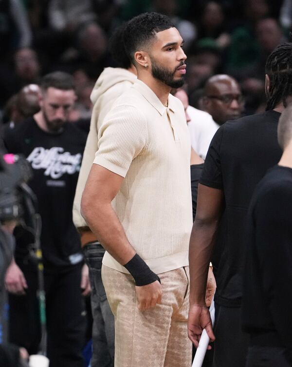 Boston Celtics forward Jayson Tatum, who is sidelined with an injury, stands near the bench with his wrist wrapped during the first half in game 2 of a first-round NBA playoff basketball series against the Orlando Magic, Wednesday, April 23, 2025, in Boston. (AP Photo/Charles Krupa)