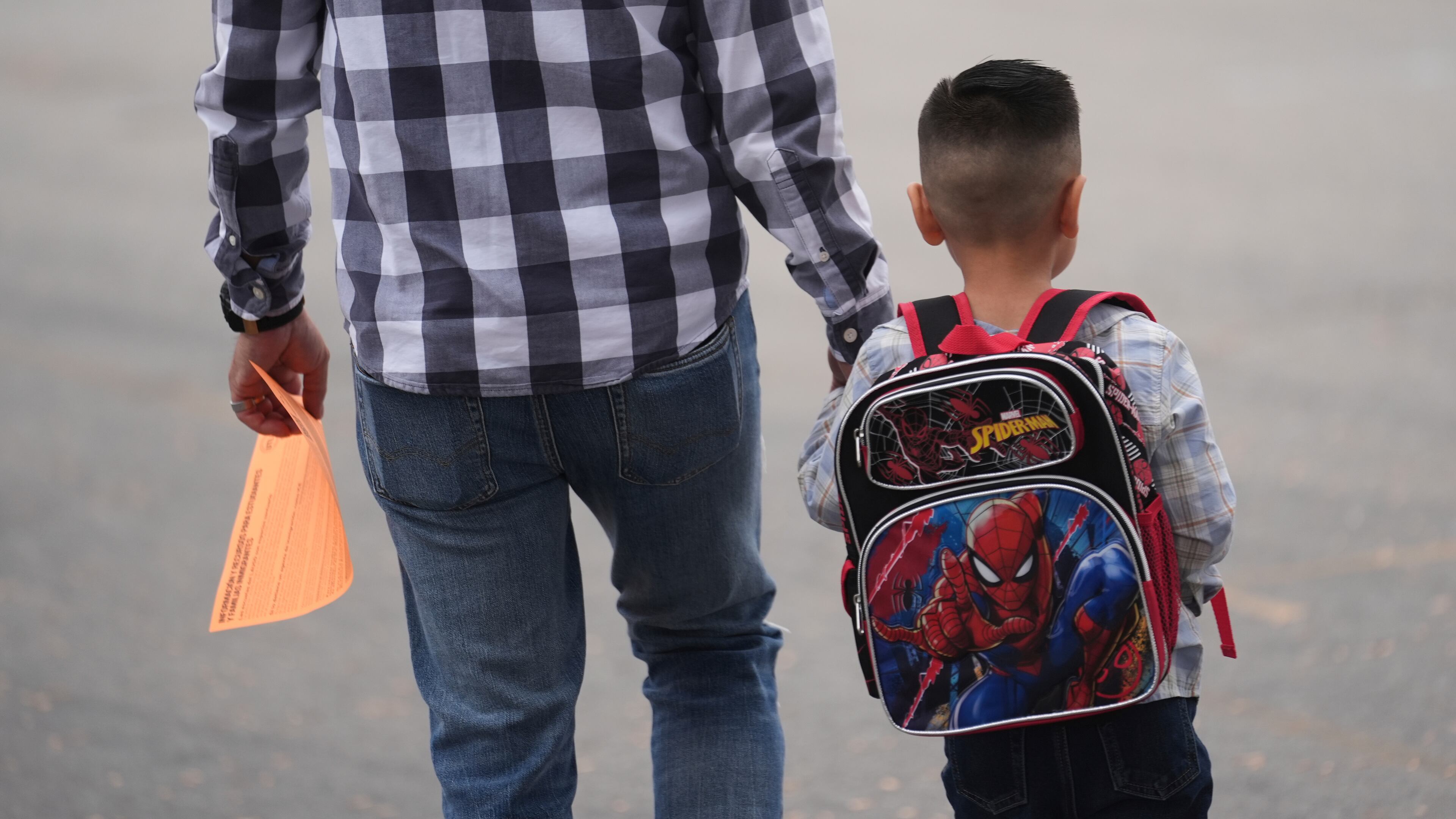 A parent and student arrive on the first day of school Thursday, Aug. 14, 2025, in Los Angeles. (AP Photo/Marcio Jose Sanchez)