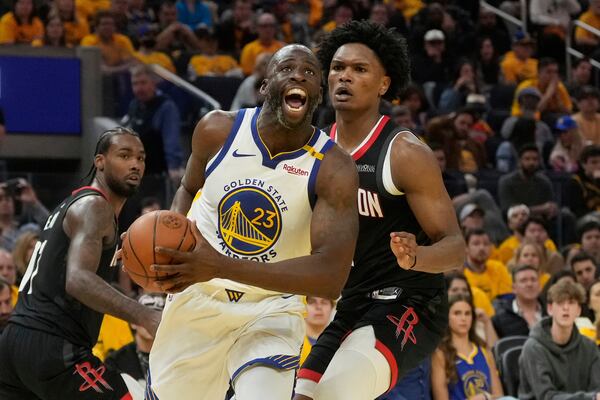 Golden State Warriors forward Draymond Green (23) drives to the basket against Houston Rockets forward Amen Thompson, right, during the first half of Game 3 of an NBA basketball first-round playoff series in San Francisco, Saturday, April 26, 2025. (AP Photo/Jeff Chiu)