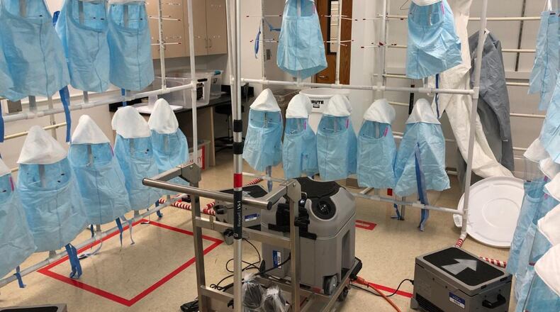 Protective hoods hang from racks at Emory University Hospital during a sterilization cycle using vaporized hydrogen peroxide. Emory is piloting a decontamination program to extend the life of single-use protective gear as hospitals face shortages fighting the coronavirus. SPECIAL TO THE AJC.