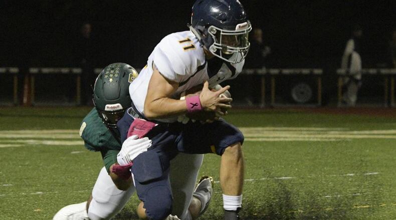 Marist QB Chase Abshier (11) is brought down by Blessed Trinity defender JR Bivens during a high school football game, Friday, Oct. 20, 2017, in Roswell. (John Amis)
