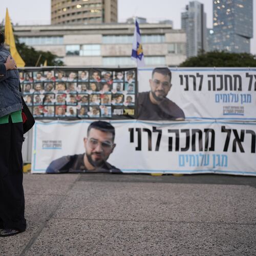 Two women embrace next to a banner with a photo of Ran Gvili after the announcement that the hostage, whose remains were the last to be recovered from Gaza, had been identified, in a plaza known as Hostages Square in Tel Aviv, Israel, Monday, Jan. 26, 2026. (AP Photo/Oded Balilty)