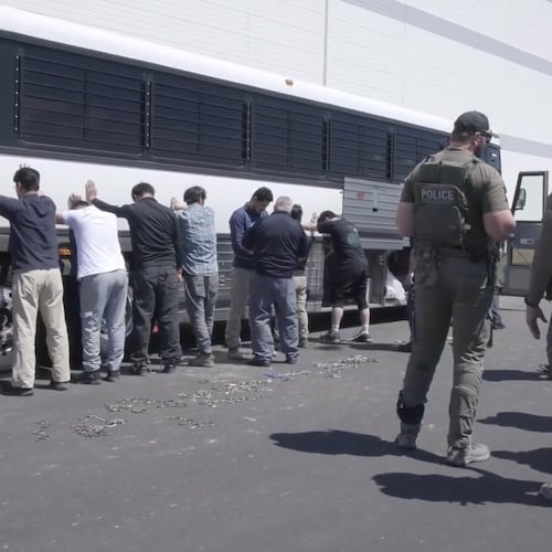 Manufacturing plant employees wait to have their legs shackled at the Hyundai Motor Group’s electric vehicle plant, Thursday, Sept. 4, 2025, in Ellabell, after an ICE raid. (Corey Bullard/U.S. Immigration and Customs Enforcement via AP)
