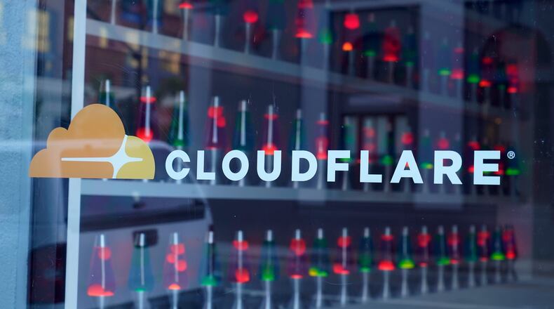 FILE - Lava lamps are seen through a lobby window at the headquarters of Cloudflare in San Francisco, on Aug. 31, 2022. (AP Photo/Eric Risberg, File)