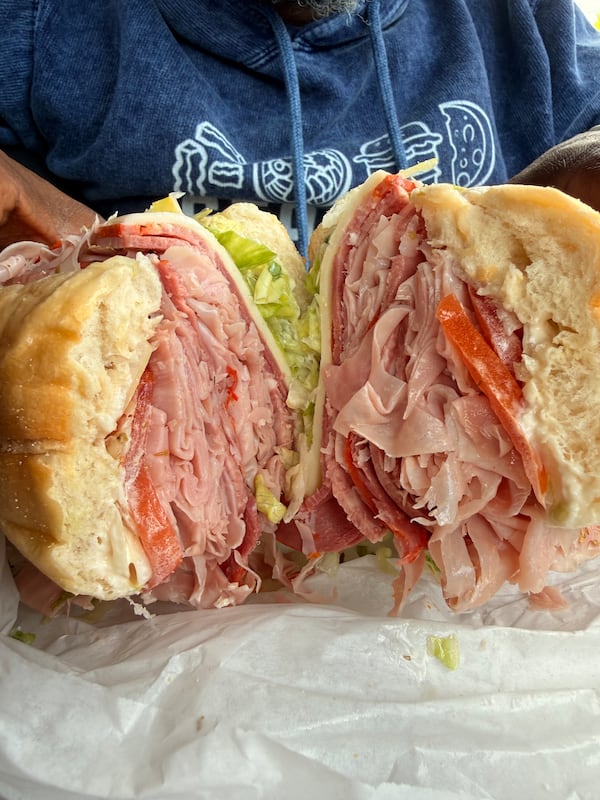A large Italian sub cut in half, with the cut side of the sandwich facing the camera.