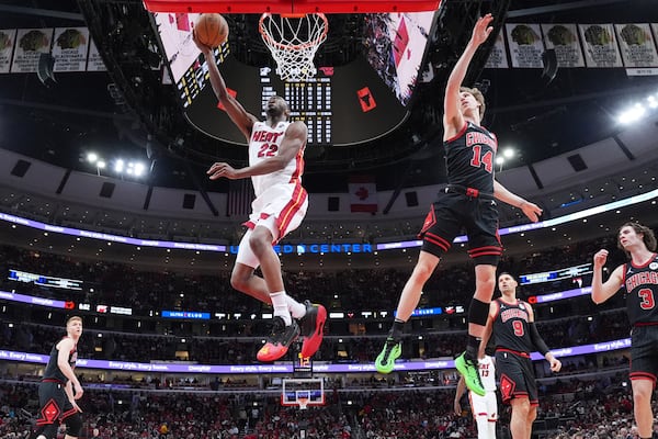 Miami Heat forward Andrew Wiggins, left, drives to the basket past Chicago Bulls forward Matas Buzelis during the first half of an NBA play-in tournament basketball game in Chicago, Wednesday, April 16, 2025. (AP Photo/Nam Y. Huh)