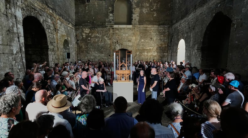 People listen to the sound of the John Cage Organ Project Halberstadt during a chord change of the organ inside the medieval Burchardi Church in Halberstadt, Germany, Wednesday, Aug. 5, 2026. (AP Photo/Markus Schreiber)