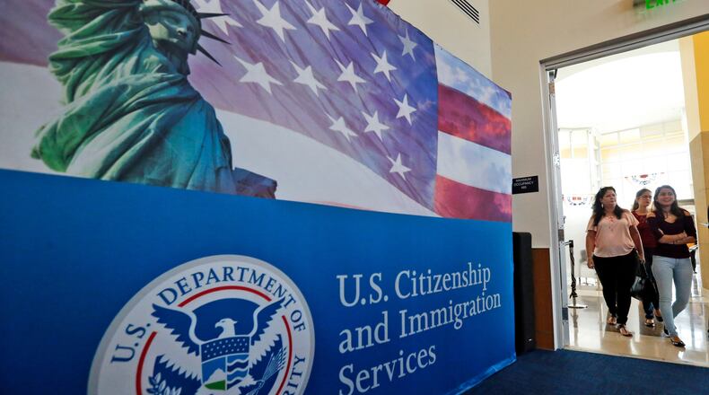 FILE - In this Aug. 17, 2018, file photo, people arrive before the start of a naturalization ceremony at the U.S. Citizenship and Immigration Services Miami Field Office in Miami. (AP Photo/Wilfredo Lee, File)