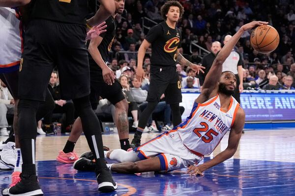 New York Knicks' Mikal Bridges (25) grabs a rebound from the floor during the second half of an NBA basketball game against the Cleveland Cavaliers Friday, April 11, 2025, in New York. (AP Photo/Seth Wenig)