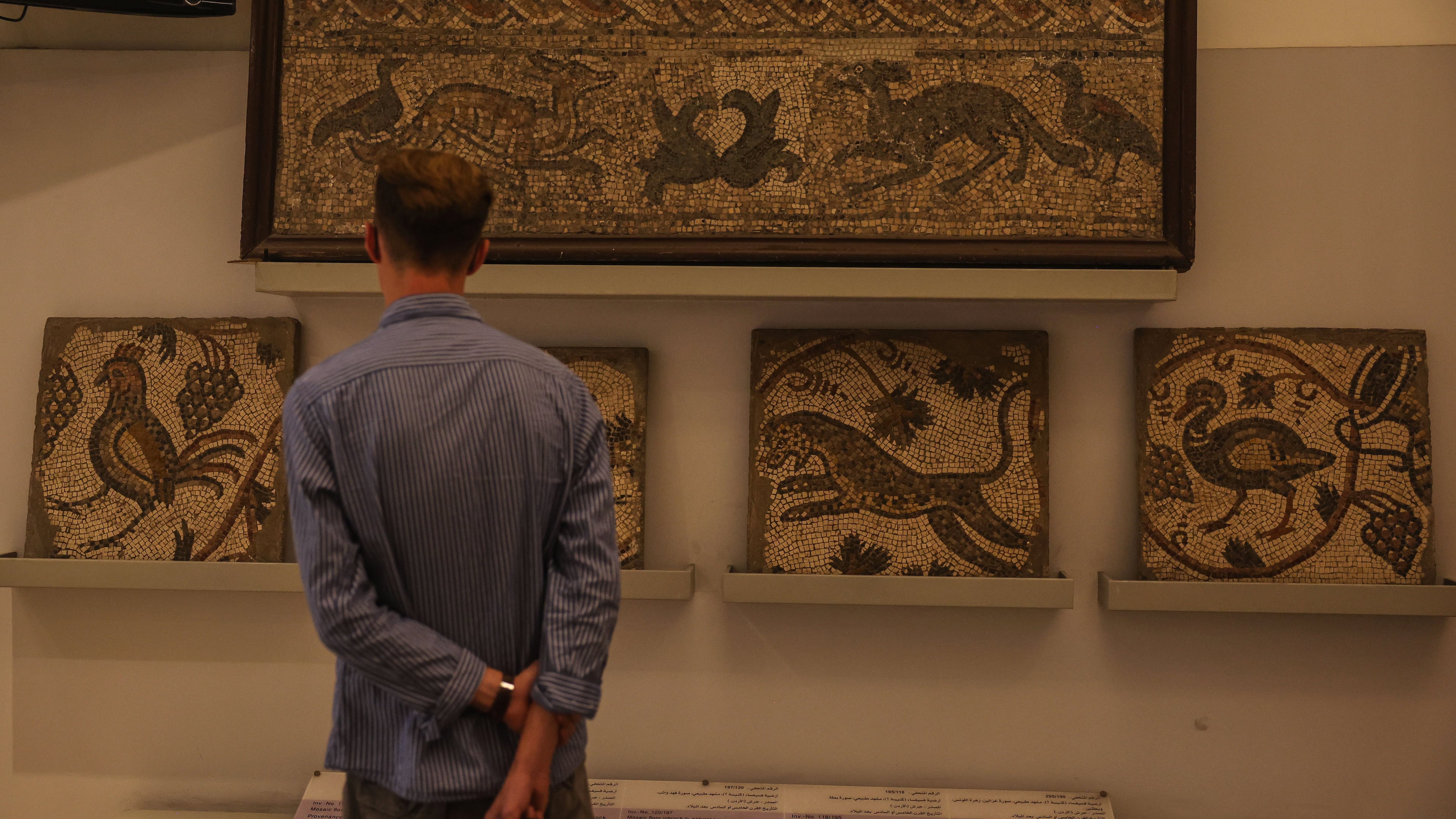 A visitor looks at ancient mosaics on display at the National Museum of Syria in Damascus, Friday, May 23, 2025. (AP Photo/Ghaith Alsayed)