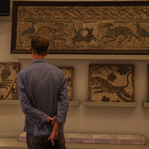 A visitor looks at ancient mosaics on display at the National Museum of Syria in Damascus, Friday, May 23, 2025. (AP Photo/Ghaith Alsayed)