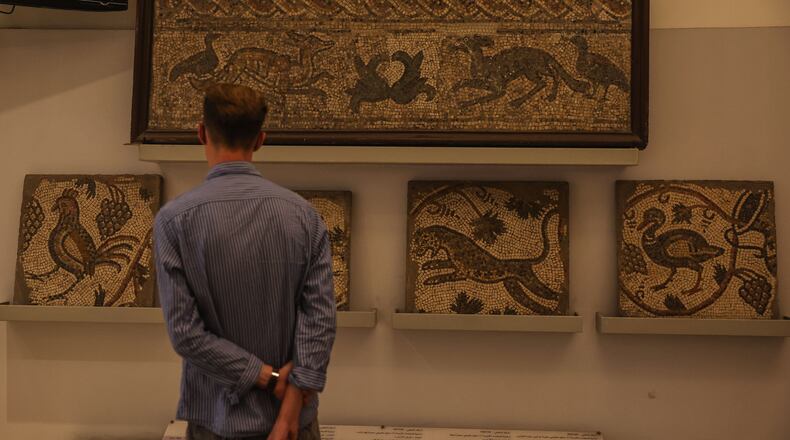 A visitor looks at ancient mosaics on display at the National Museum of Syria in Damascus, Friday, May 23, 2025. (AP Photo/Ghaith Alsayed)