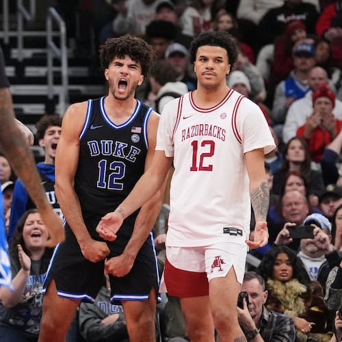 Duke forward Cameron Boozer (12) celebrates after scoring as Arkansas forward Malique Ewin (12) looks on during the second half of an NCAA college basketball game in the CBS Sports Thanksgiving Classic tournament Thursday, Nov. 27, 2025, in Chicago. (AP Photo/Nam Y. Huh)