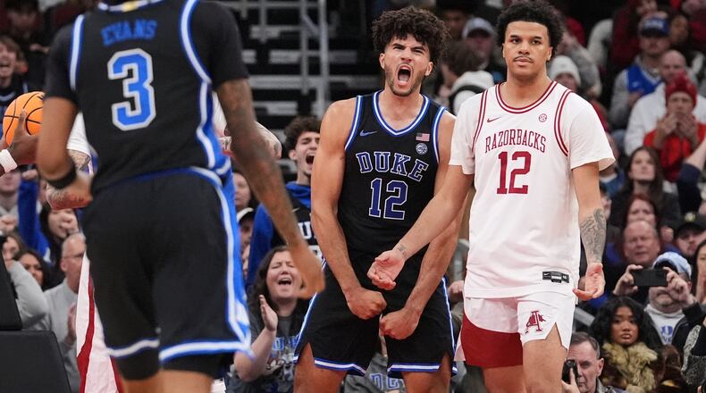Duke forward Cameron Boozer (12) celebrates after scoring as Arkansas forward Malique Ewin (12) looks on during the second half of an NCAA college basketball game in the CBS Sports Thanksgiving Classic tournament Thursday, Nov. 27, 2025, in Chicago. (AP Photo/Nam Y. Huh)