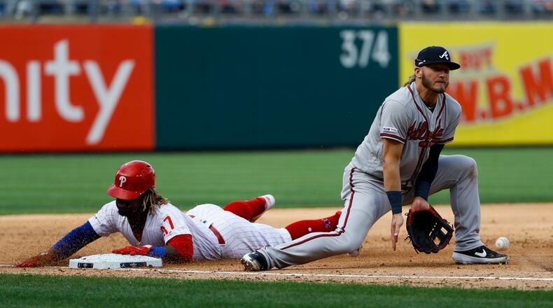 Philadelphia Phillies' Odubel Herrera slides into third base on a wild pitch by Atlanta Braves starting pitcher Julio Teheran as third baseman Josh Donaldson digs out the throw from home during the fourth inning of an opening day baseball game, Thursday, March 28, 2019, in Philadelphia. (AP Photo/Matt Slocum)