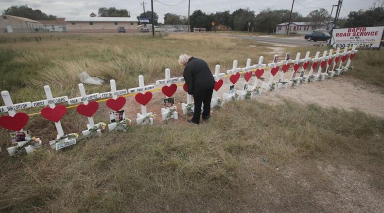 SUTHERLAND SPRINGS, TX - NOVEMBER 09: Helen Biesenbach leaves a message at a memorial where 26 crosses were placed to honor the 26 victims killed at the First Baptist Church of Sutherland Springs on November 9, 2017 in Sutherland Springs, Texas. On November 5, a gunman, Devin Patrick Kelley, shot and killed the 26 people and wounded 20 others when he opened fire during Sunday service at the church. Biesenbach, a member of the church, missed the November 5 service because she was babysitting her two-year-old grandson who was home with a fever. Biesenbach knew all the victims whose names are written on the crosses. (Photo by Scott Olson/Getty Images)