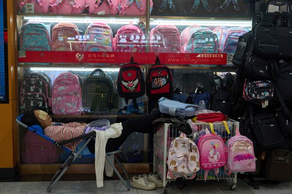A vendor naps near bags for sale at the Yiwu International Trade Market in Yiwu, eastern China's Zhejiang province on Thursday, April 10, 2025. (AP Photo/Ng Han Guan)