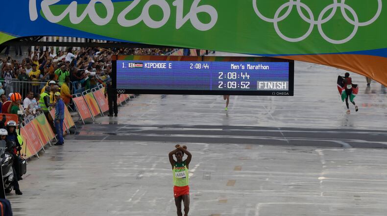 Ethiopia's Feyisa Lilesa crosses his arms as he crosses the finish line to win the silver medal in the men's marathon at the 2016 Summer Olympics in Rio de Janeiro, Brazil, Sunday, Aug. 21, 2016. (AP Photo/Luca Bruno)