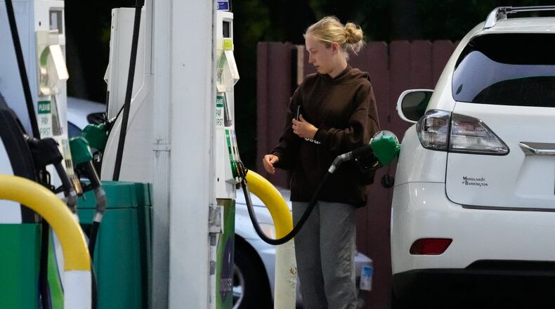 Customer checks gas price before she fills up her vehicle's tank at a gas station in Lincolnshire, Ill., Monday, June 8, 2026. (AP Photo/Nam Y. Huh)