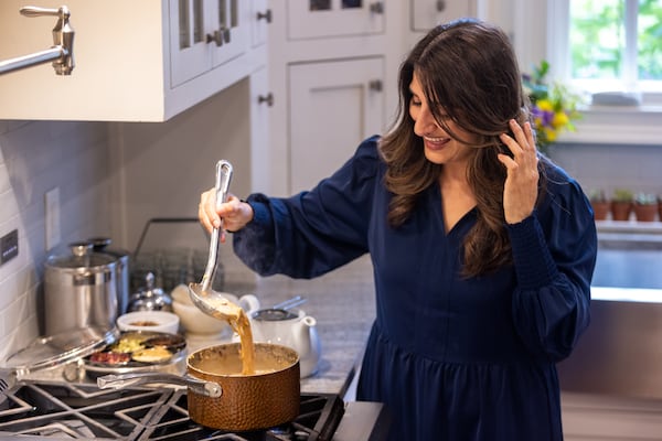 Monica Sunny, founder of the Chai Box tea company, demonstrates the process of making a pot of chai at her home in Marietta. Sunny found popularity in her daily chai meditations that she livestreamed on social media for her followers. (Arvin Temkar/AJC)