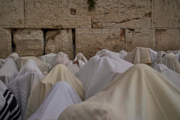Covered in prayer shawls, Jewish men of the Cohanim Priestly caste participate in a blessing during the holiday of Passover, at the Western Wall, the holiest site where Jews can pray, in the Old City of Jerusalem, Tuesday, April 15, 2025. (AP Photo/Leo Correa)