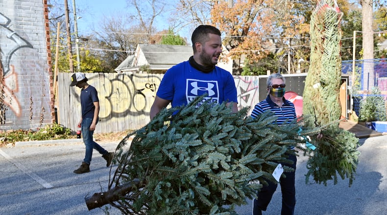 Kevin Goez, manager, helps Pat Redmond, long-time customer, with loading her Christmas tree at Northstar Christmas Trees in East Atlanta on Thursday, December 2, 2021. (Hyosub Shin / Hyosub.Shin@ajc.com)