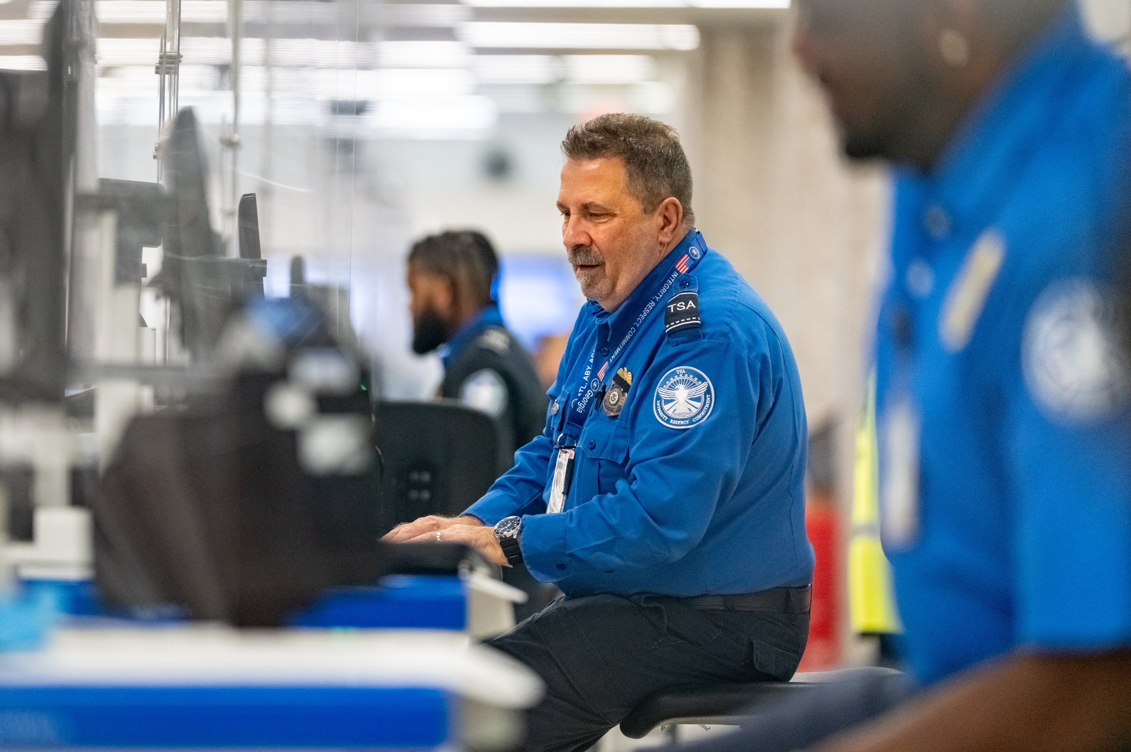A Transportation Security Administration Agent checks the identification of travelers at Hartsfield-Jackson Atlanta International Airport.
