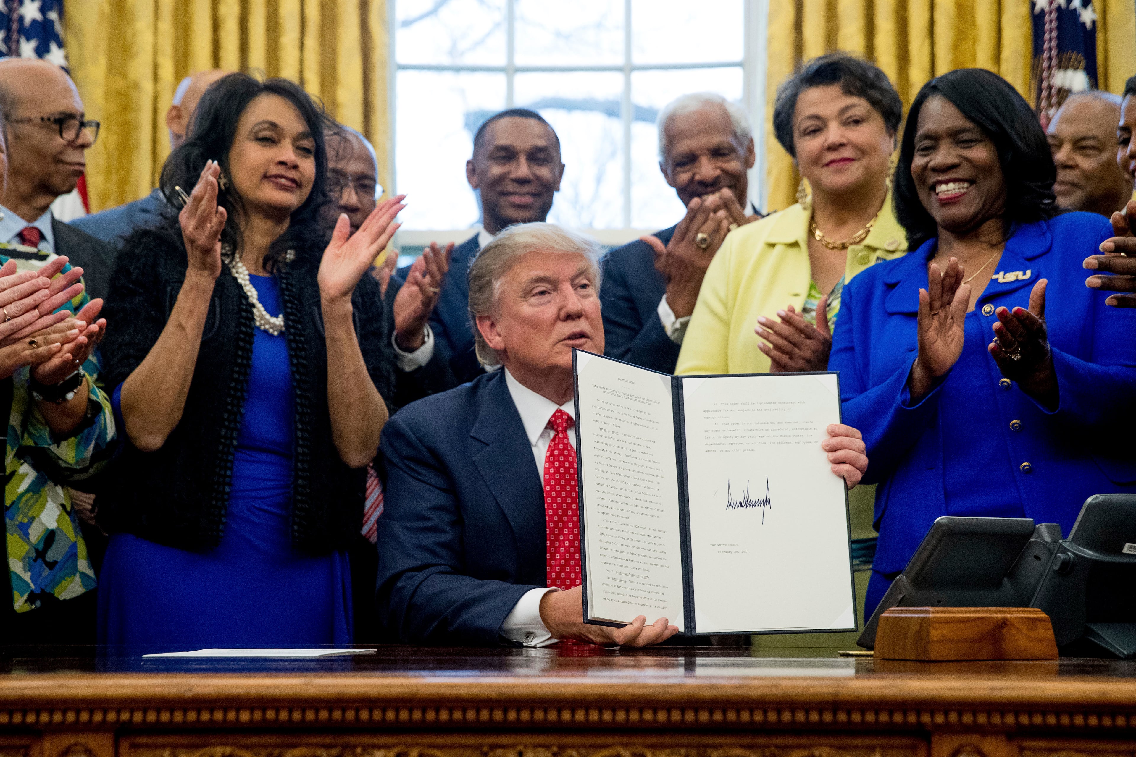 President Donald Trump holds up the Historically Black Colleges and Universities HBCU Executive Order after signing it on Feb. 28, 2017, in the Oval Office in the White House in Washington. (Andrew Harnik/AP)