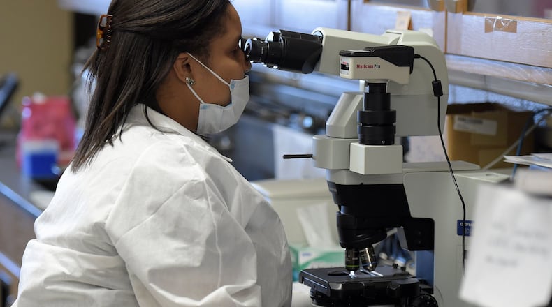 Scientist Lanisha Gittens analyzes evidence in the serology lab this week at the GBI Crime Laboratory. KENT D. JOHNSON/ kdjohnson@ajc.com