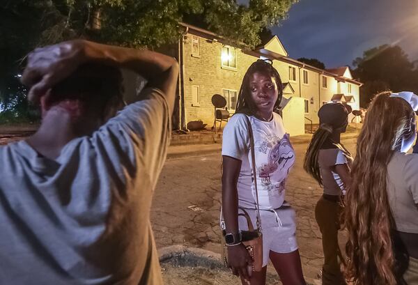 Tiwana McCoy (center) said her cousin was shot and killed on his 13th birthday outside an apartment building in southwest Atlanta. Another 13-year-old was also killed, and a 12-year-old was hospitalized. 