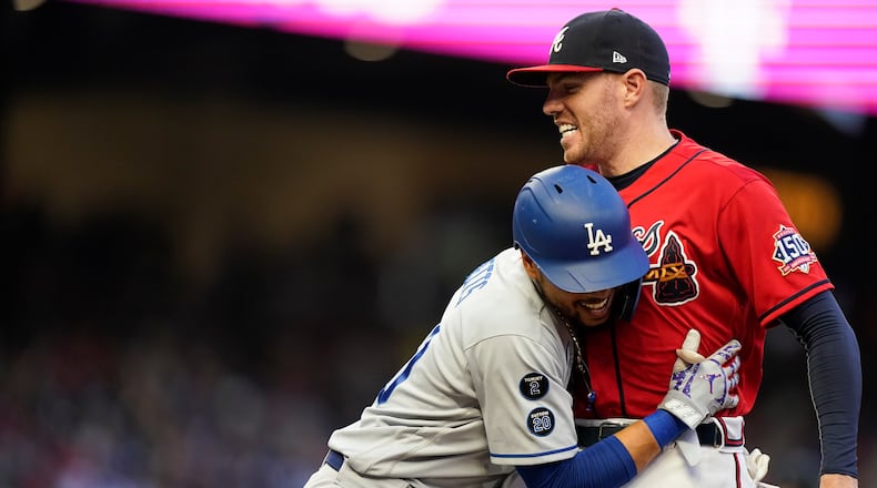 Atlanta Braves' Freddie Freeman greets Los Angeles Dodgers' Mookie Betts at first base in the fourth inning Friday, June 4, 2021, in Atlanta. (AP Photo/Brynn Anderson)