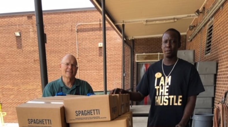Jim Gossling, manager of the Atlanta Bishops’ Storehouse for the Church of Jesus Christ of Latter-day Saints, helps Red Shield staffer, Randolph Brown, with first load of food supplies for the shelter. Contributed