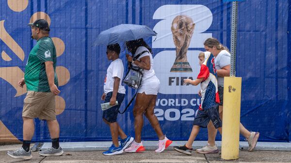 Soccer fans walk in the rain to Atlanta Stadium (Mercedes-Benz Stadium) for the South Africa versus Czechia match in June. (Ben Hendren for the AJC)
