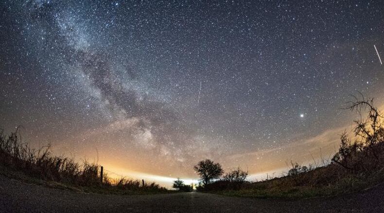 The milky way and traces of meteors illuminate the sky over Burg on the Baltic Sea island of Fehmarn, northern Germany, Friday, April 20, 2018, during the Lyrid meteor shower. (Daniel Reinhardt/dpa via AP)