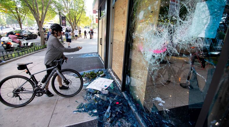 People stop to take photographs of the damage near the CNN center after the George Floyd protest Saturday, May 30, 2020. STEVE SCHAEFER FOR THE ATLANTA JOURNAL-CONSTITUTION