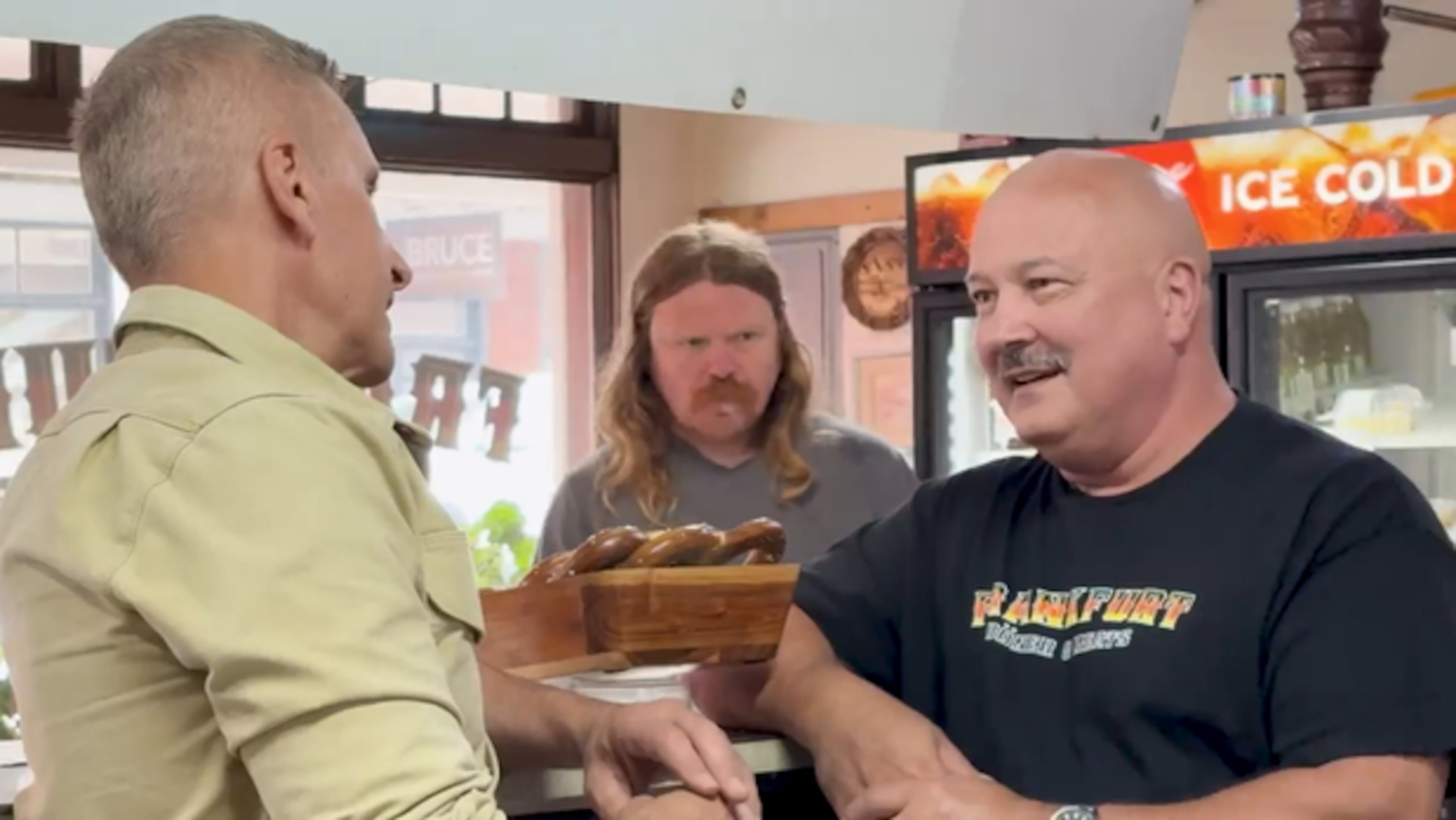 Brian Unger (left) interviews Dean Corbett, chief marketing officer of the Frankfurt Doner & Meats restaurant, pitching a "life-changing sandwich" in Ball Ground. (Courtesy CBS News Atlanta)