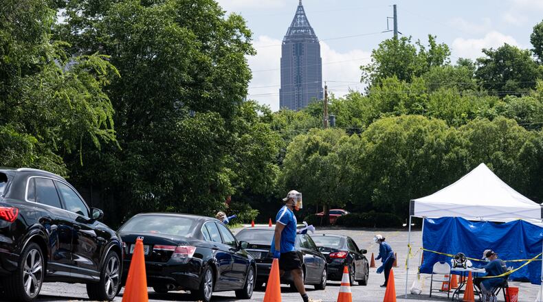 200716-Atlanta-Workers at a CORE testing site at Antioch Baptist Church North in Northwest Atlanta collect covid-19 tests from a line of cars that disappears and wraps around the block Thursday afternoon July 16, 2020. Ben Gray for the Atlanta Journal-Constitution