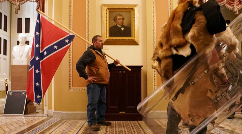 A man carries a Confederate flag as a mob protests the presidential election results, inside the Capitol in Washington on Wednesday, Jan. 6, 2021. The Trump era has been marked by open expressions of racial bigotry. (Erin Schaff/The New York Times)