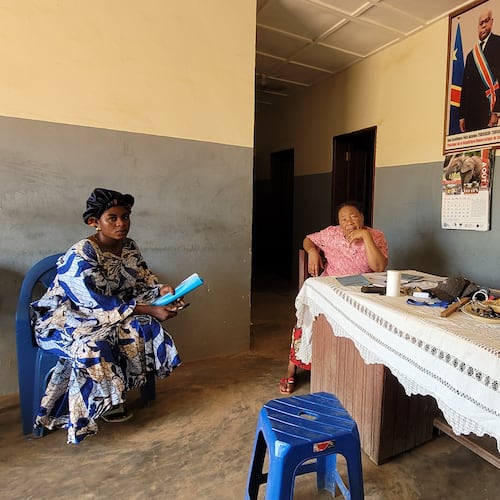 Parents who came for their children's school resumption sit inside an office of a school in Ituri province, eastern Congo, Thursday, Aug. 27, 2026. (AP Photo/Constant Same Bagalwa)