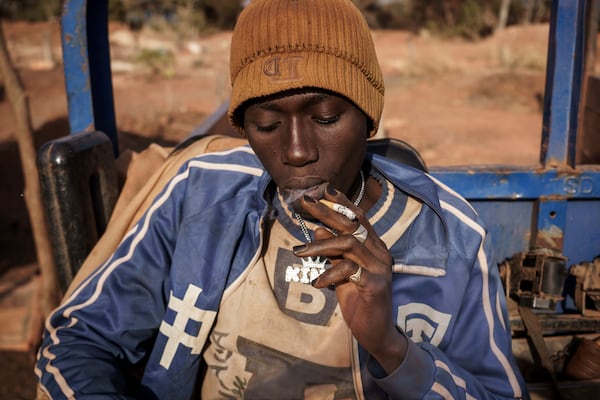 A gold miner takes a cigarette break at a mining site in the Kedougou region of Senegal on Thursday, Jan. 16, 2025. (AP Photo/Annika Hammerschlag)