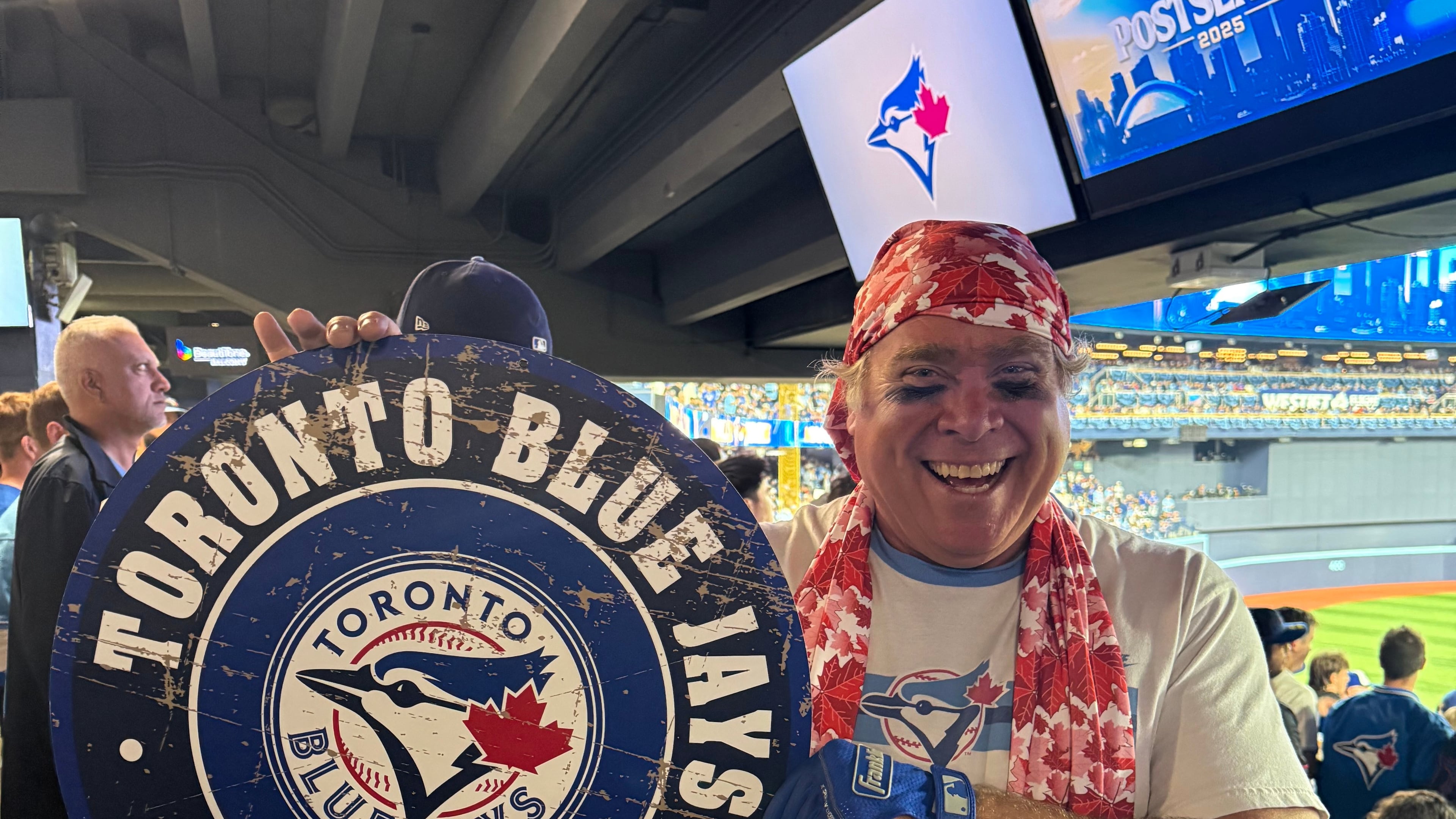 Toronto Blue Jays fan Geoffrey Fulton poses with his Blue Jays gear and maple leaf bandana during Game 7 of baseball's American League Championship Series between the Blue Jays and Seattle Mariners in Toronto, Monday, Oct. 20, 2025. (AP Photo/Rob Gillies)