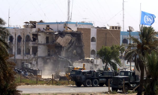 FILE - U.S. military vehicles pass the collapsed section of the United Nations headquarters Saturday, Aug. 23, 2003, in Baghdad, Iraq. (AP Photo/Manish Swarup, File)