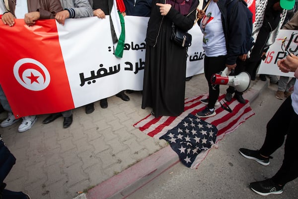 Protesters walk on a U.S flag outside the U.S. Embassy to condemn U.S., British, and Israeli military actions in Palestine, Yemen, and Syria, Saturday, April 5, 2025 in Tunis. (AP Photo/Ons Abid) f