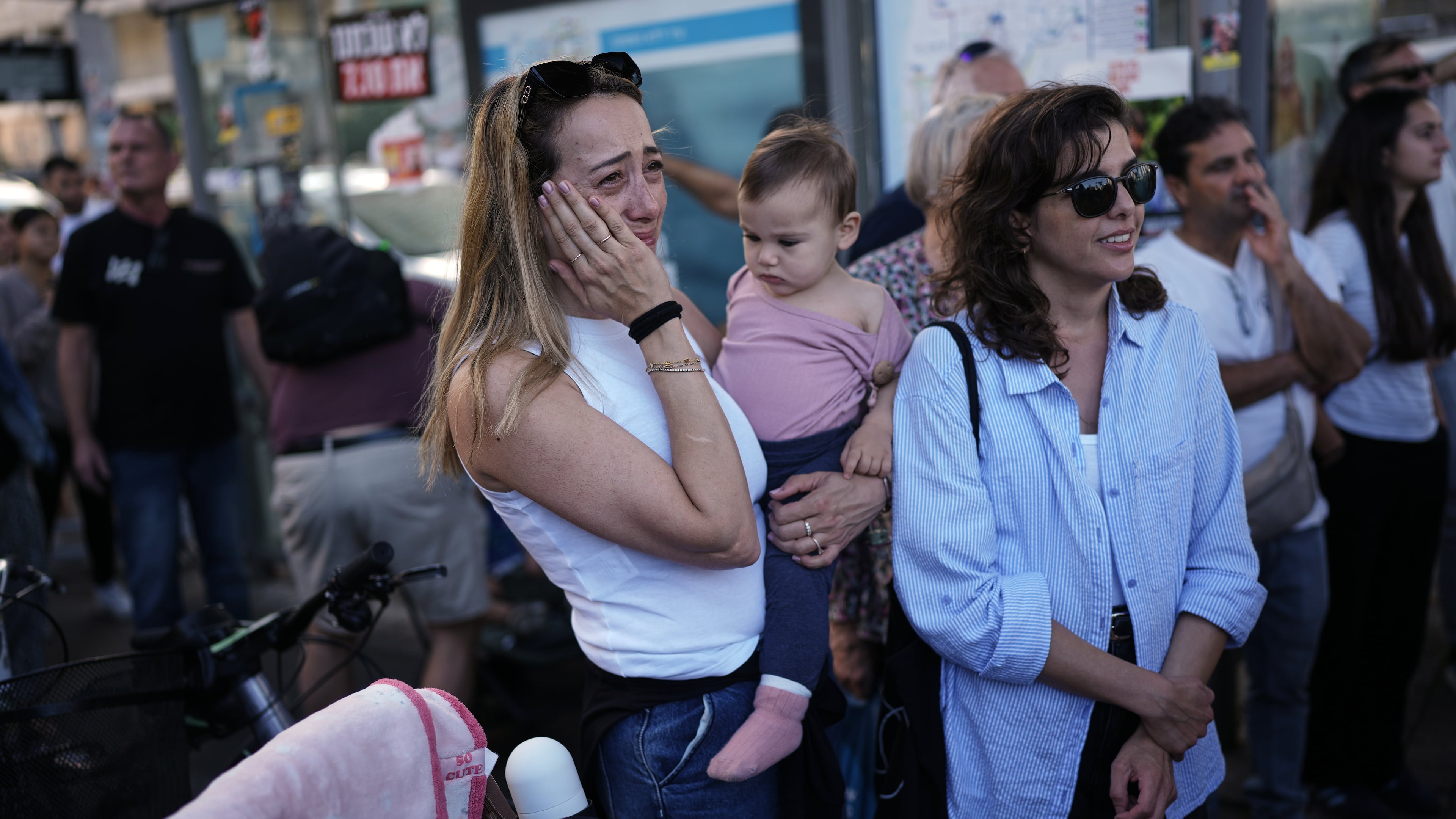 People react as they gather to watch a live broadcast of Israeli hostages released from Gaza at a plaza known as hostages square in Tel Aviv, Israel, Monday, Oct. 13, 2025. The release took place as part of a cease-fire agreement between Israel and Hamas. (AP Photo/Oded Balilty)