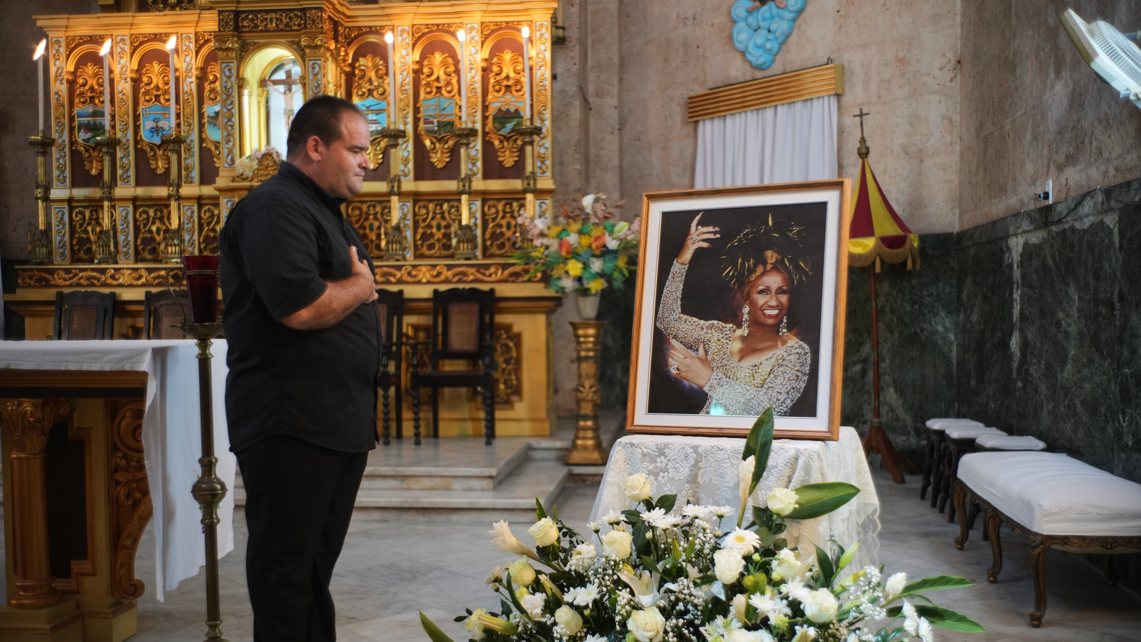 A man stands before a framed image of late singer Celia Cruz after attending a memorial Mass marking the centennial of her birth at the Virgen del Cobre or Our Lady of Charity church in Havana, Tuesday, Oct. 21, 2025. (AP Photo/Ramon Espinosa)