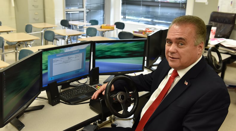 Alan Brown with a driving simulator at Cartersville High School. Following the death of his teenage son, Brown pushed for a law that mandated drivers’ education, Joshua’s Law, to be paid for with fees on speeding tickets. BRANT SANDERLIN/BSANDERLIN@AJC.COM