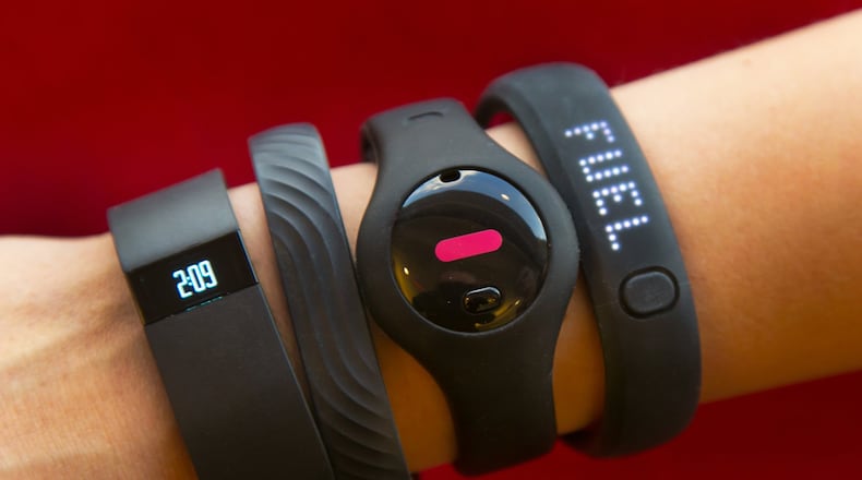 Four fitness trackers are shown in this photograph, in New York, Monday, Dec. 16, 2013. They are, from left, Fitbit Force, Jawbone Up, Fitbug Orb, and the Nike FuelBand SE. For aspiring health nuts and to inspire couch potatoes to get active, the latest crop of fitness gadgets will record much more than how many steps you took on any given day. From sleep patterns to calorie intake, mood and progress toward exercise goals, few aspects of life are left un-tracked for those in search for a more quantified self.